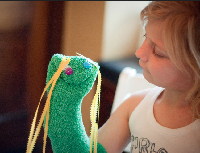 Girl with green hand sock puppet