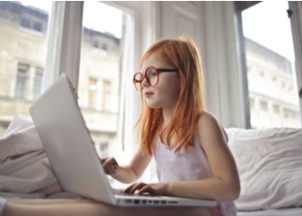girl with glasses in front of computer